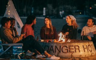 A diverse group of people gathered around a warm campfire, symbolizing the connection and community fostered by the digital campfire in B2B tech marketing