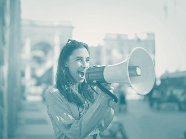 Young woman with a bullhorn, symbolising the power of content marketing for startups in amplifying brand storytelling and reaching potential customers.